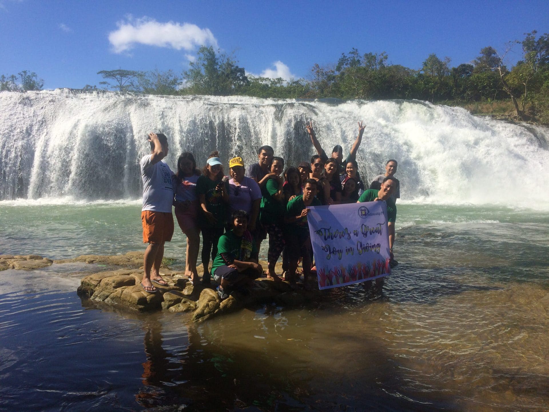 A group of people on a falls holding a tarpaulin